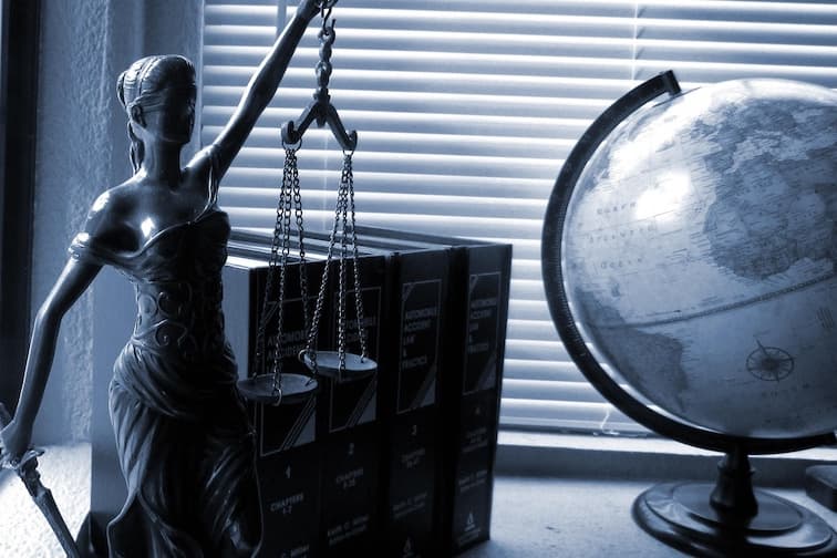 Petite statue en métal d’une femme drapée à l’antique sur un bureau de juriste.