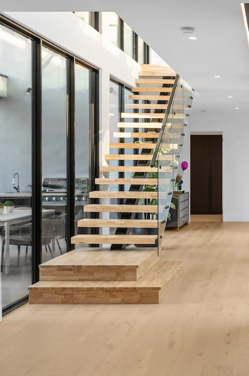 Escalier en bois de hêtre massif sans contremarche avec garde-corps en verre.